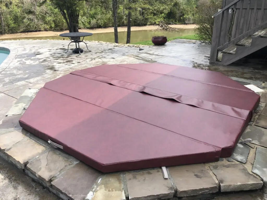 Burgundy spa cover on a stone patio