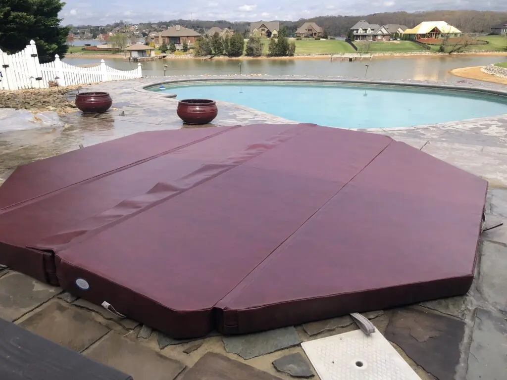 Burgundy octagonal spa cover beside a swimming pool